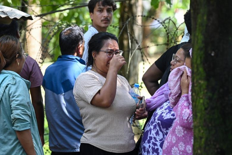 Personas reaccionan mientras esperan la llegada de sus familiares a un campamento del ejército tras ser rescatados de zonas afectadas por inundaciones repentinas, en la localidad de Battar Bazar, distrito de Nuwakot (Nepal)