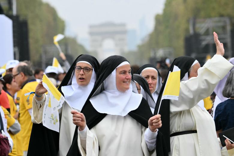 Las monjas vitorean mientras se reúnen para asistir a una misa solemne al aire libre celebrada por el papa León XIV en la Place de la Concorde
