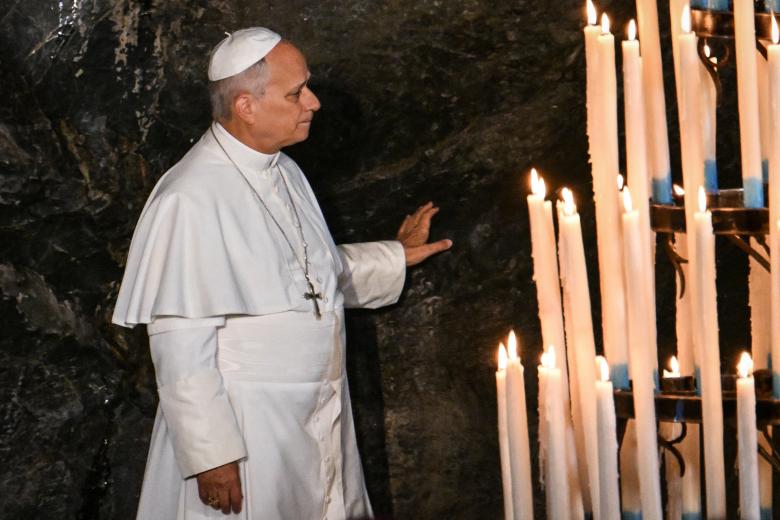 Pope Leo XIV touches the rock at the Grotto of Massabielle in the Sanctuary of Our Lady of Lourdes during a prayer with worshippers on September 26, 2026 on the second day of his visit to France. (Photo by Alberto PIZZOLI / AFP)