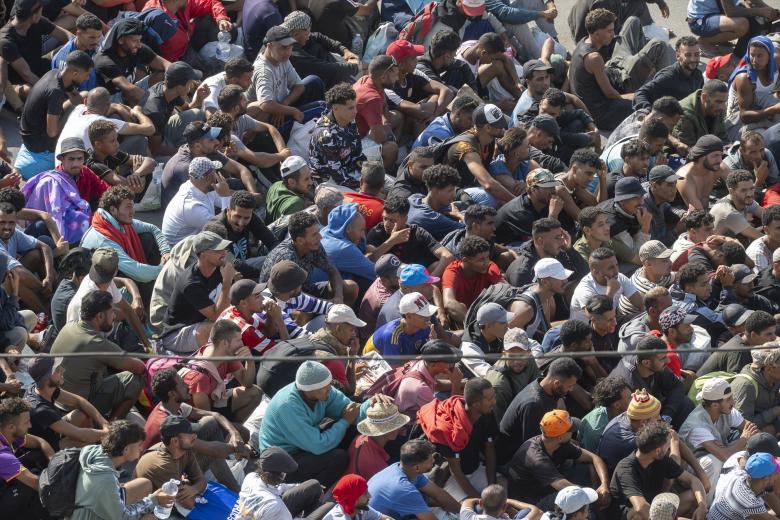 Migrantes desalojados de la playa del Trampolín de camino a ser reubicados, a 20 de agosto de 2026, en Ceuta (España). La Policía ha comenzado a desalojar el campamento improvisado de migrantes en la playa del Trampolín de Ceuta. La ciudad autónoma sigue afrontando una grave crisis humanitaria después de la histórica entrada masiva de más de 70.000 migrantes a nado por el Tarajal durante los días 30 y 31 del pasado mes de julio.
