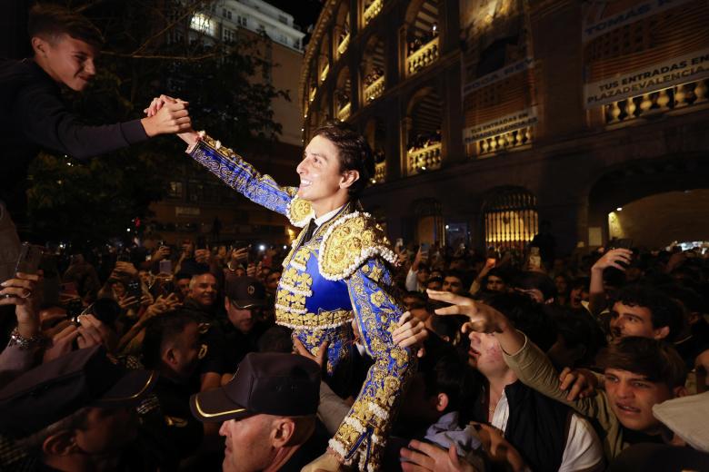 Roca Rey saluda a un joven aficionado tras abrir la Puerta Grande de Valencia.