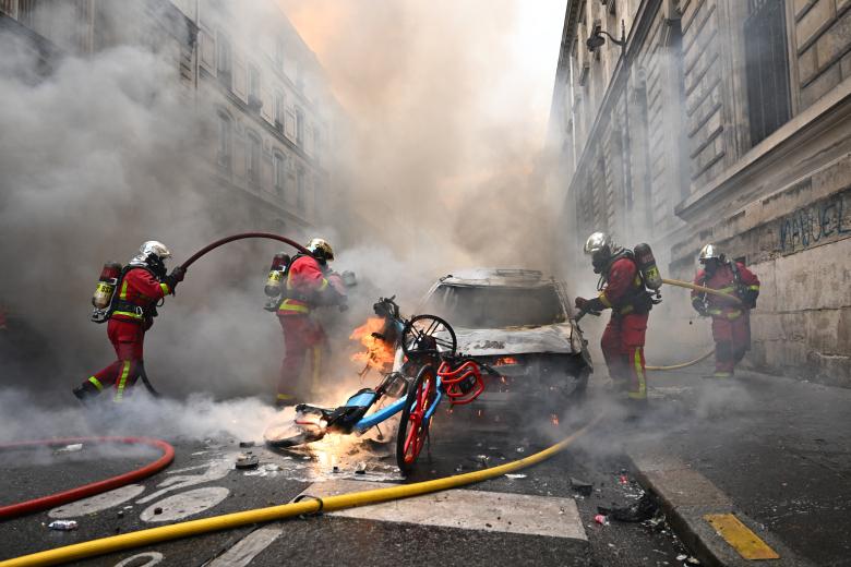 Los bomberos franceses apagan un coche y un bicicleta en llamas en el centro de París
