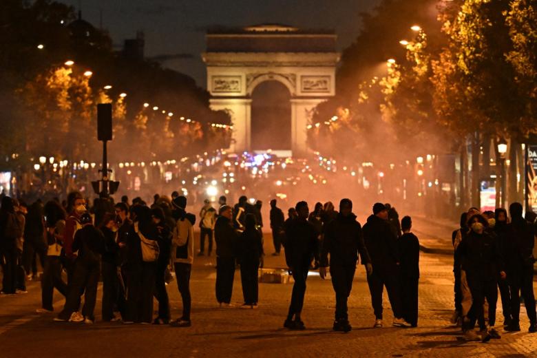Paris (France), 17/10/2026.- A cafe waiter tries to push back tear gas canisters during clashes between protesters and police at a demonstration against rising living costs and cuts to public services in Paris, France, 17 October 2026. The nationwide mobilization brought together Yellow Vest (Gilets Jaunes) activists, high school and university students, trade unions and other groups protesting rising living costs, fuel prices and deteriorating public services, while demanding improvements in education and school conditions. (Protestas, Francia) EFE/EPA/MOHAMMED BADRA