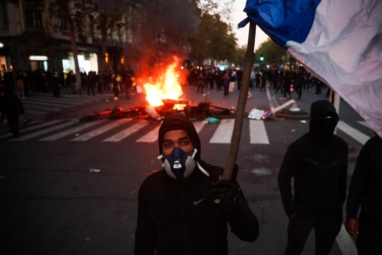 Protesters gather on the Champs-Elysees Avenue with the Arc de Triomphe in the background during a demonstration to protest against the "high cost of living", in Paris on October 17, 2026 as part of a nationwide call for mobilisation bringing together various groups expressing their anger: former "Yellow Vest", secondary school and university students, climate activists and even farmers. After weeks of student protests, France faces broader, nationwide demonstrations on October 17, 2026 over the cost of living, setting up a potentially fraught six months heading into a presidential election. A police source told AFP that authorities estimated nearly 200,000 people could take part, with 40,000 in Paris. (Photo by Guillaume Saligot / AFP)