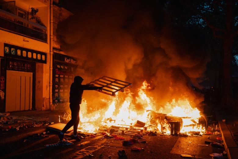 Demonstrators feed a fire with materials on Boulevard Haussmann during ongoing protest against the "high cost of living", in Paris on October 17, 2026 as part of a nationwide call for mobilisation bringing together various groups expressing their anger: former "Yellow Vests", secondary school and university students, climate activists and even farmers. After weeks of student protests, France faces broader, nationwide demonstrations on October 17, 2026 over the cost of living, setting up a potentially fraught six months heading into a presidential election. A police source told AFP that authorities estimated nearly 200,000 people could take part, with 40,000 in Paris. (Photo by Guillaume Saligot / AFP)