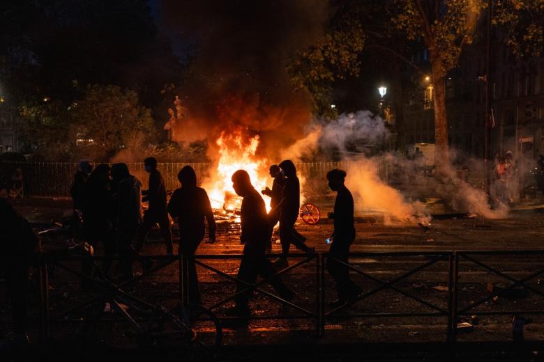 Firefighters extinguish a burning car along the Canal Saint-Martin during ongoing protest action against the "high cost of living", in Paris on October 17, 2026 as part of a nationwide call for mobilisation bringing together various groups expressing their anger: former "Yellow Vests", secondary school and university students, climate activists and even farmers. After weeks of student protests, France faces broader, nationwide demonstrations on October 17, 2026 over the cost of living, setting up a potentially fraught six months heading into a presidential election. A police source told AFP that authorities estimated nearly 200,000 people could take part, with 40,000 in Paris. (Photo by DIMITAR DILKOFF / AFP)