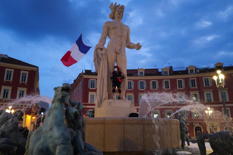 People run amid the smoke at the Place Massena during a demonstration against the "high cost of living", in Nice, southern France, on October 17, 2026 as part of a nationwide call for mobilisation bringing together various groups expressing their anger: former "Yellow Vest", secondary school and university students, climate activists and even farmers. After weeks of student protests, France faces broader, nationwide demonstrations on October 17, 2026 over the cost of living, setting up a potentially fraught six months heading into a presidential election. A police source told AFP that authorities estimated nearly 200,000 people could take part, with 40,000 in Paris. (Photo by Valery HACHE / AFP)
