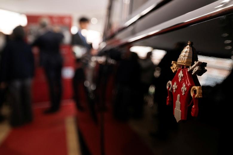 Visitors look at one of the historic papal vehicles on display at the Square Garden (Giardino Quadrato) during the press preview of the "A Century of Papamobile" exhibition, in the Vatican Museums, at the Vatican, on October 28, 2026. The exhibition "A century of the Popemobile", that presents eight historic vehicles mapping 100 years of papal mobility will open its doors on October 29, 2026. (Photo by TIZIANA FABI / AFP)