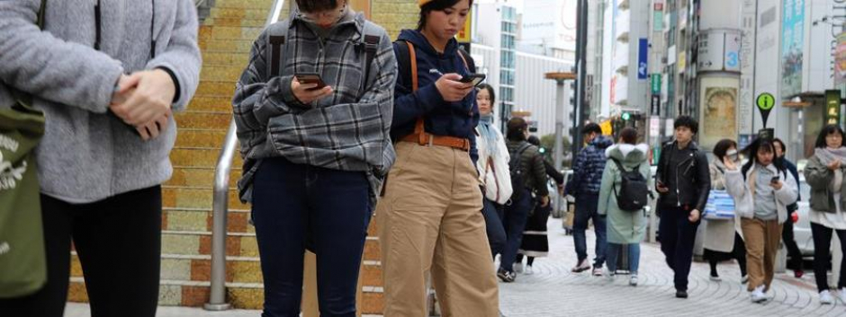 Jóvenes utilizan el móvil en las calles