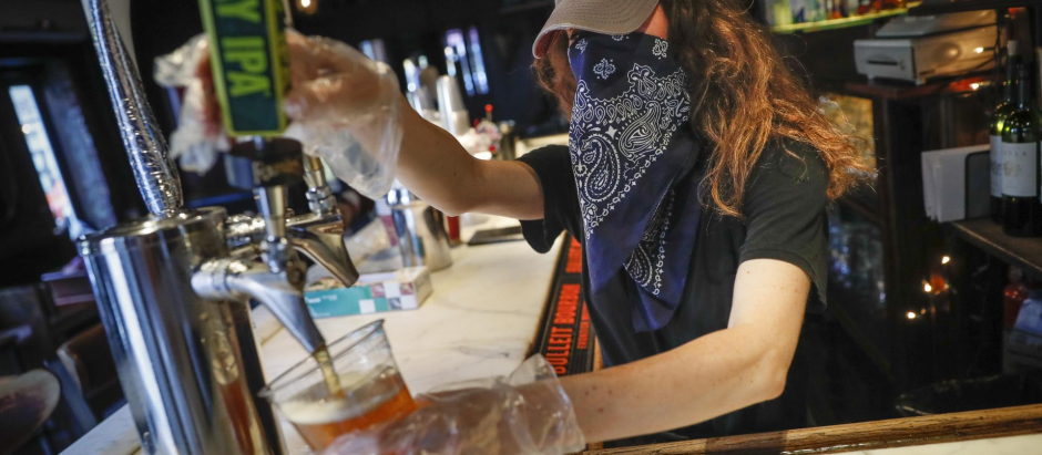 Una camarera sirve una cerveza en un bar de Estados unidos