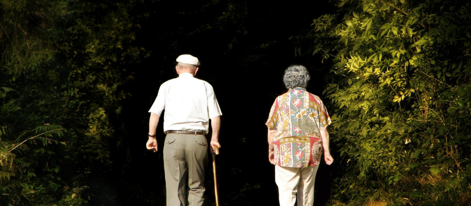 Una pareja de pensionistas caminan por las cercanías de su municipio