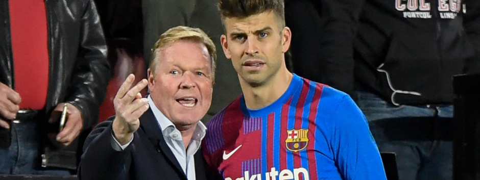 Barcelona's Dutch coach Ronald Koeman (L) gives instructions to Barcelona's Spanish defender Gerard Pique during the Spanish League football match between Rayo Vallecano de Madrid and FC Barcelona at the Vallecas stadium in Madrid on October 27, 2021. (Photo by OSCAR DEL POZO / AFP)