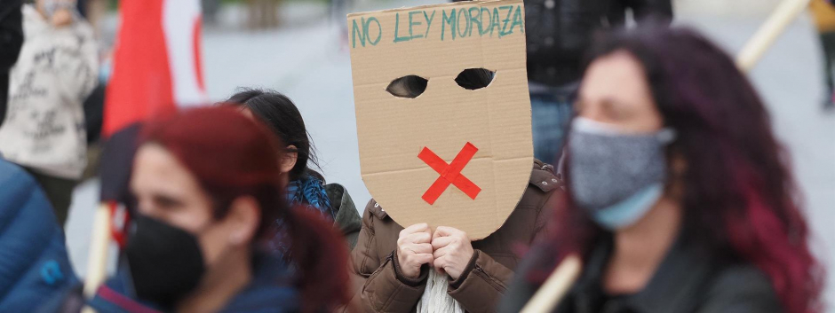 Una persona sostiene una careta donde se lee "No Ley Mordaza" durante una manifestación contra el encarcelamiento de Pablo Hassel