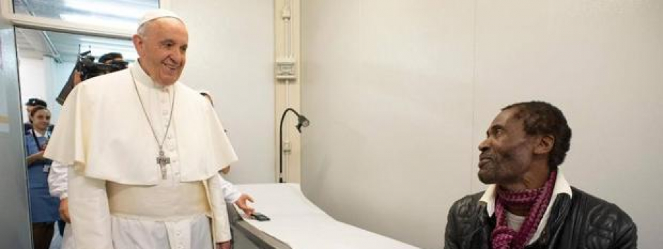 El papa Francisco (i) conversa con un paciente durante su visita sorpresa al ambulatorio que ha instalado el Vaticano para atender a personas vulnerables y sin recursos