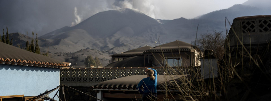 Una mujer observa el volcán de Cumbre Vieja antes de abandonar su vivienda