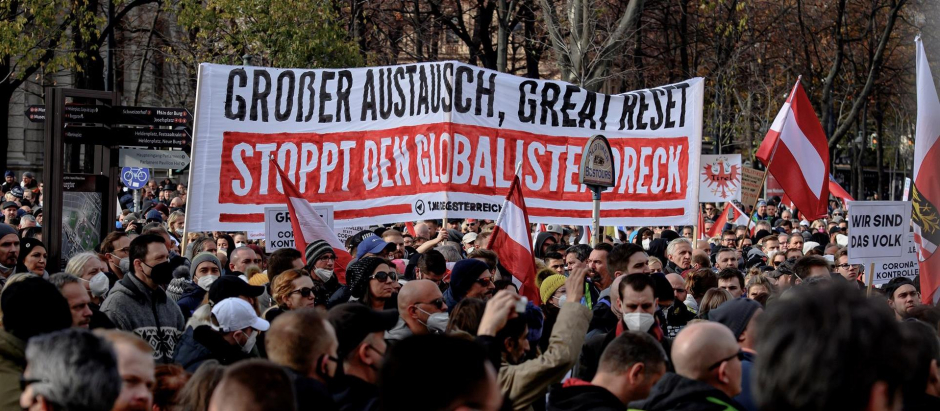 Manifestantes marchan el viernes en Viena bajo una pancarta que reza «Gran intercambio, gran reinicio, detengan la basura globalista»