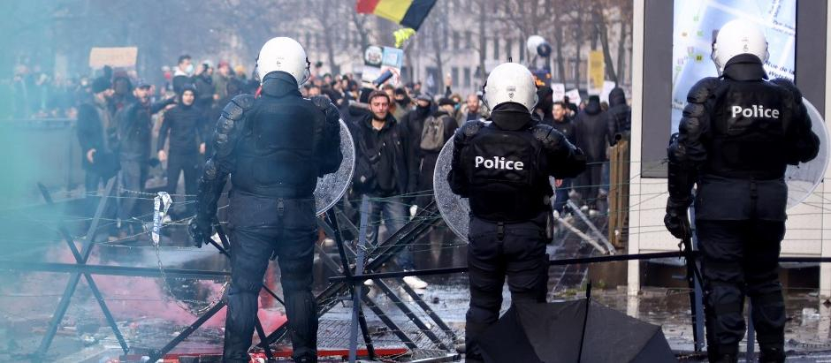 Varias personas protestan frente a la policía belga después de que el Ejecutivo de Bruselas haya endurecido las medidas para frenar el aumento de casos de coronavirus y haya implantado la obligatoriedad de las vacunas.