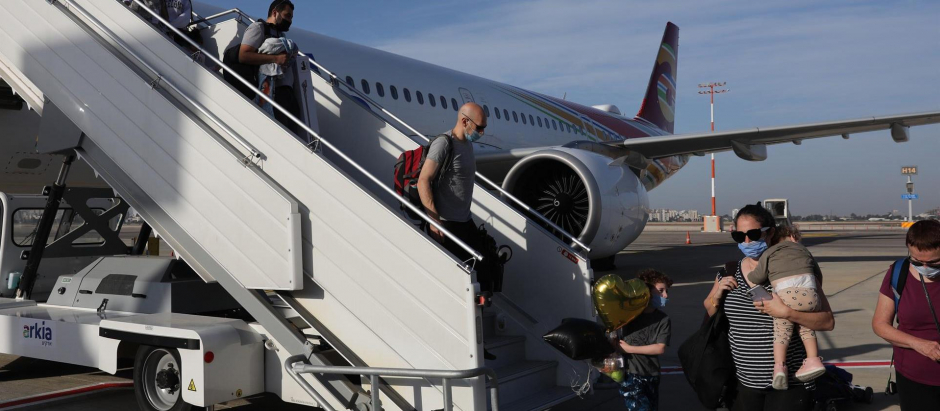 Varios pasajeros desembarcan de un avión recién aterrizado al aeropuerto israelí de Ben Gurion, este domingo