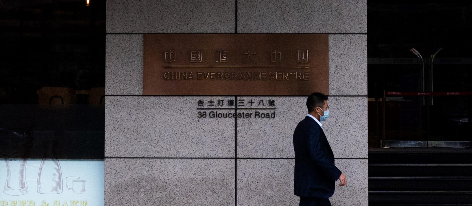 Un hombre camina frente a la sede del Centro Evergrande en Hong Kong