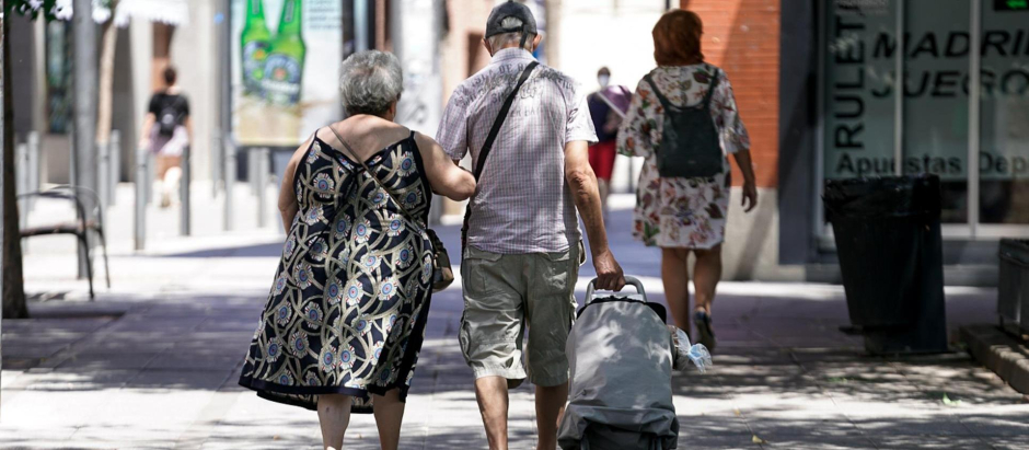 Una pareja de ancianos pasea por Madrid