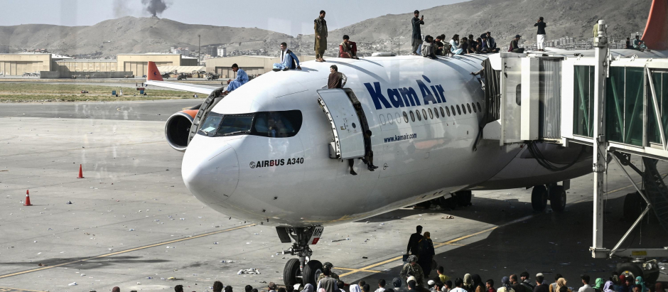 Afganos escalan un avión en el aeropuerto de Kabul en un intento de huir de los talibanes
