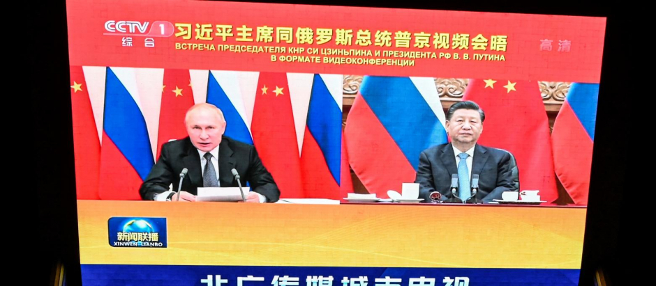 Una pantalla muestra la reunión virtual entre Vladimir Putin y Xi Jinping