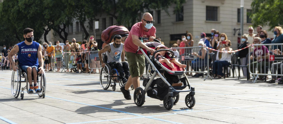 Un niño con movilidad reducida compite en agosto en la primera Carrera Infantil Adaptada en las fiestas de Sant Roc (Barcelona)