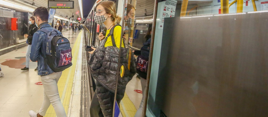 Varias personas salen de un vagón de un tren en la Estación de Metro de Ciudad Universitaria de Madrid