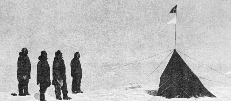 Amundsen junto a los miembros que integraron la expedición. Se puede ver la tienda erigida con la bandera de Noruega