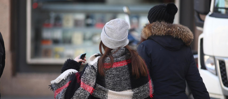 Jóvenes abrigados pasean por Madrid en un día de invierno