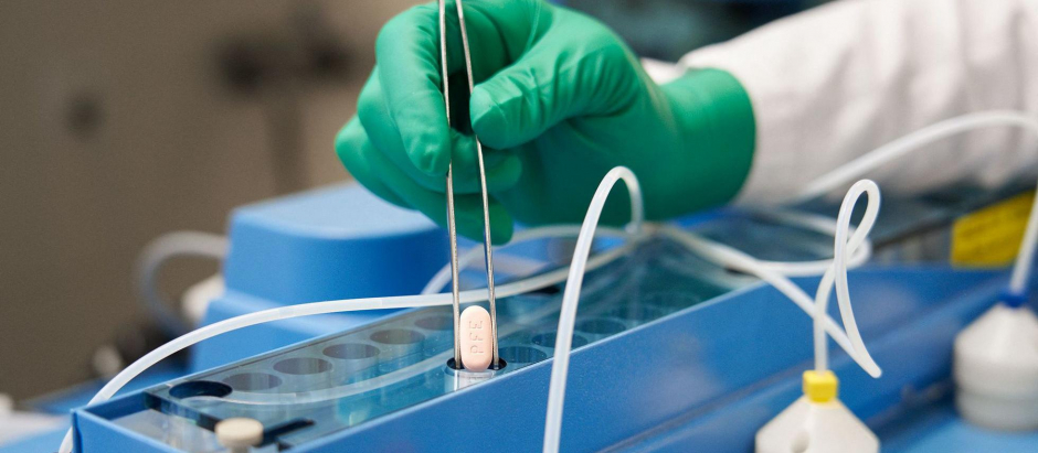 Un técnico maneja una pastilla de Paxlovid en un laboratorio de Pfizer en Alemania