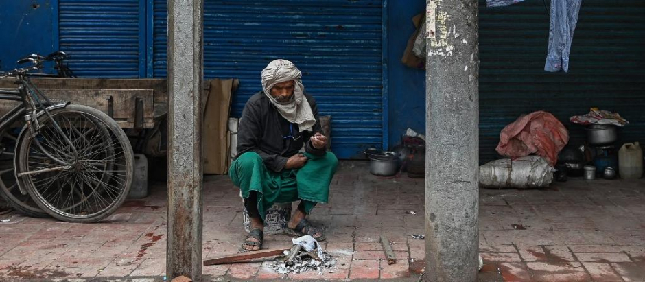 Un hombre pide dinero a las afueras de Delhi, en la India