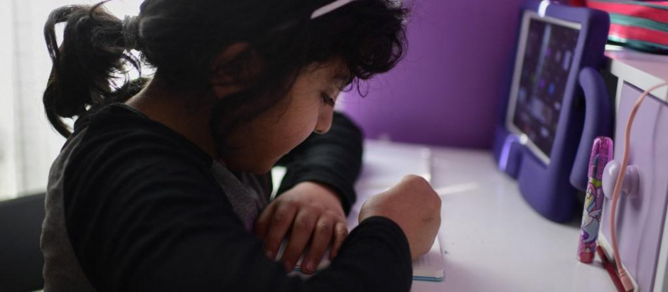 Elena Delgado, de nueve años, haciendo deberes en su casa