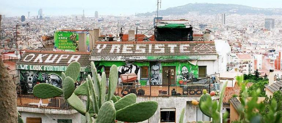 Vista aérea de una vivienda con una pintada que incita a la okupación en Barcelona
