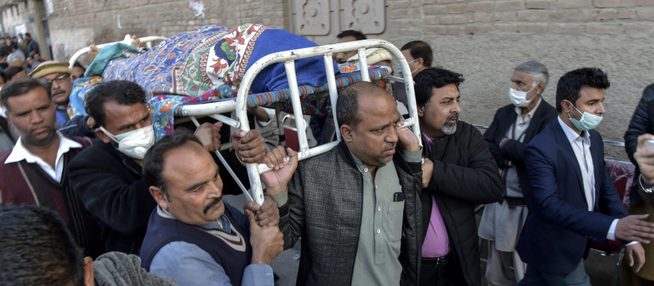 Fieles cristianos pakistaníes portan los restos mortales del sacerdote asesinado este domingo, 30 de enero