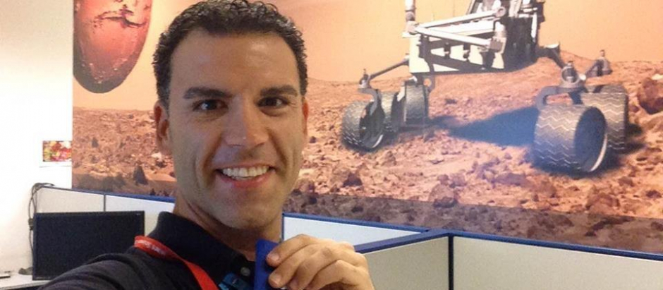 El astrobiólogo Jorge Pla-García posa en un autorretrato con una imagen del rover Curiosity de fondo