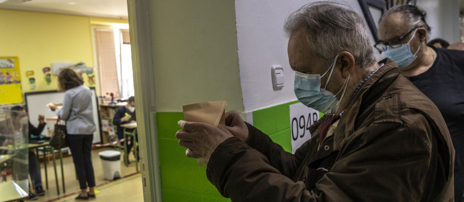 Un hombre introduce su papeleta en el sobre de votación, el pasado mayo, en Madrid
