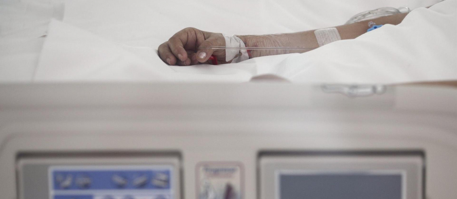 Mano de un enfermo con vía subcutánea en una cama de la UCI del Hospital de Emergencias Isabel Zendal, Madrid