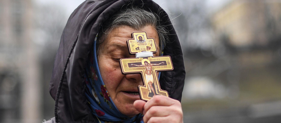 Una mujer en ucrania, portando un Cristo crucificado, en la plaza de Kiev al comienzo de la guerra