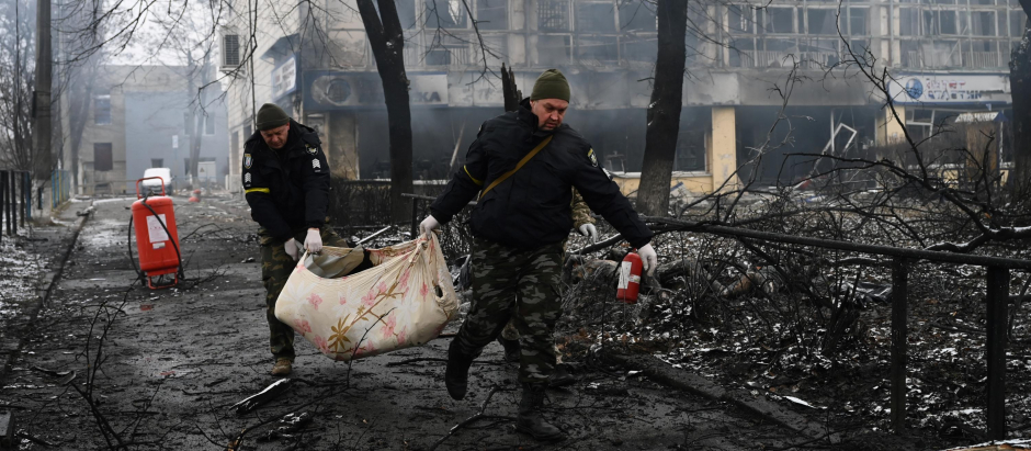 gentes de policía retiran el cuerpo de un transeúnte muerto durante un bombardeo en Kiev