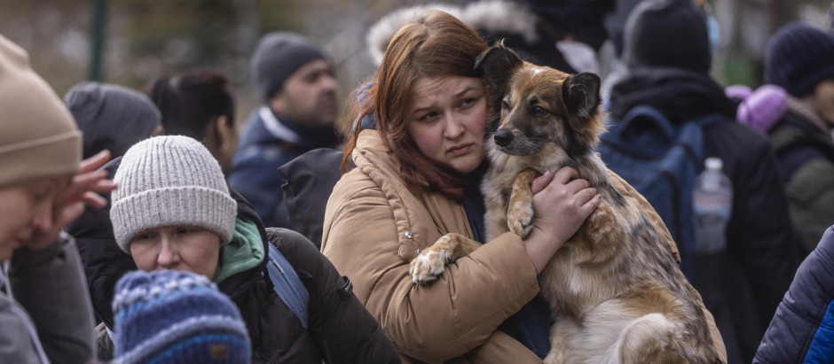 Una mujer refugiada abraza a su perro al llegar a la frontera entre Ucrania y Polonia
