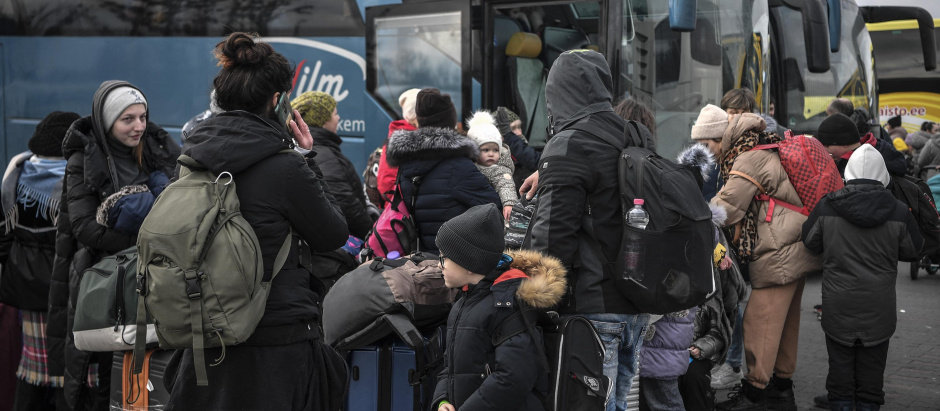 Un grupo de refugiados hace cola para subir a un autobús en la frontera entre Polonia y Ucrania, este martes