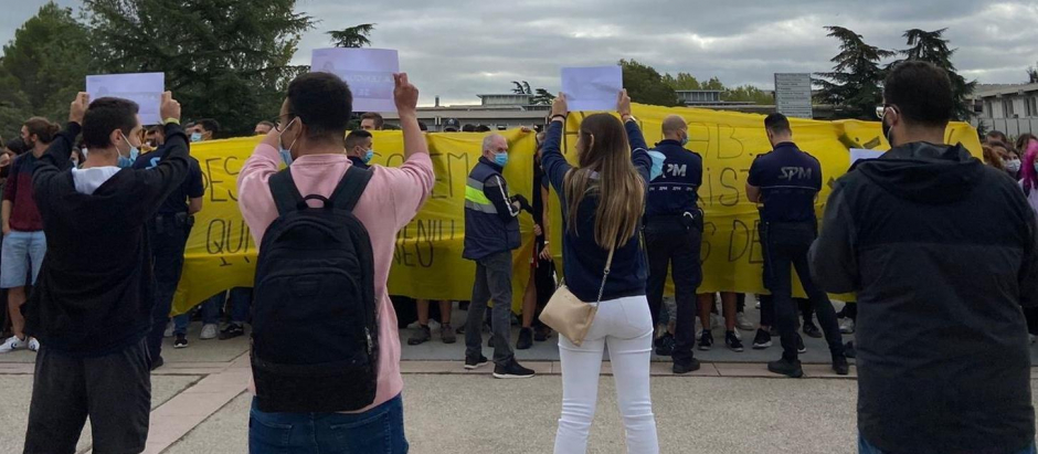 Miembros de la organización estudiantil 'S'ha acabat!' exhiben carteles frente a una concentración ante su carpa informativa en el campus de la UAB