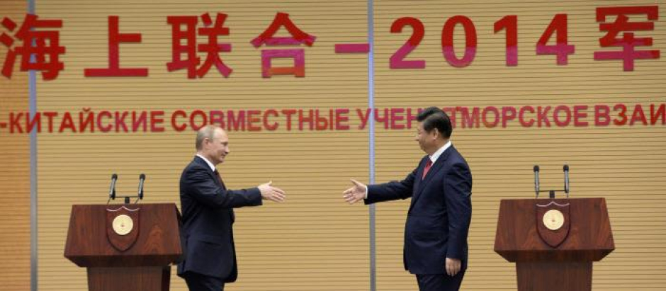 El presidente ruso, Vladimir Putin saluda a Xi Jinping, durante un acto conjunto en Shanghai en 2014