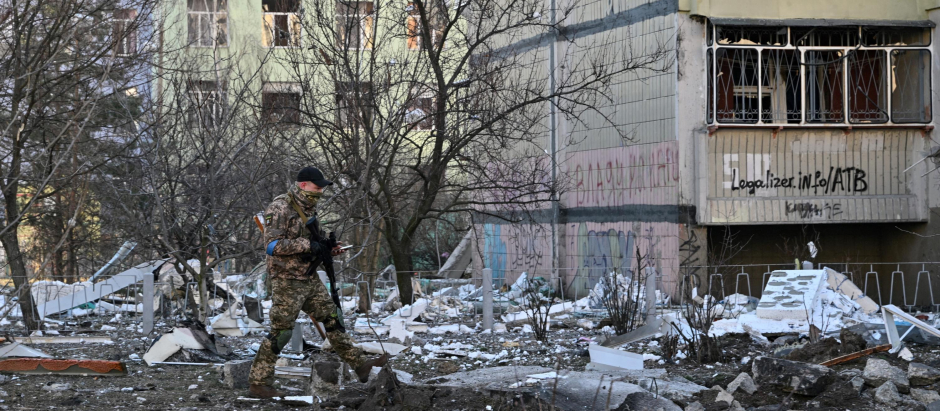 Un soldado ucraniano vigila el entorno de un bloque de apartamentos bombardeado en Kiev, este jueves