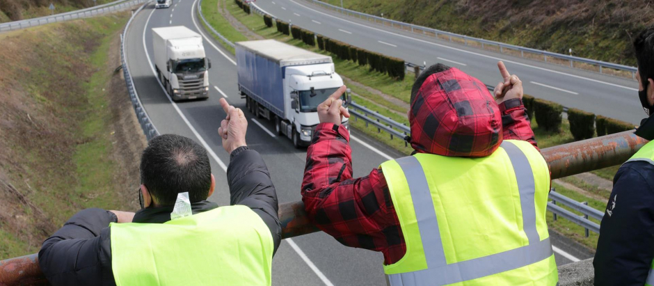 Dos miembros de un piquete insultan y hacen gestos a los camiones durante la huelga de transportes