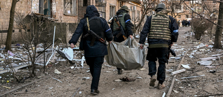 Policías ucranianos transportan un cadáver tras un bombardeo a un edificio residencial