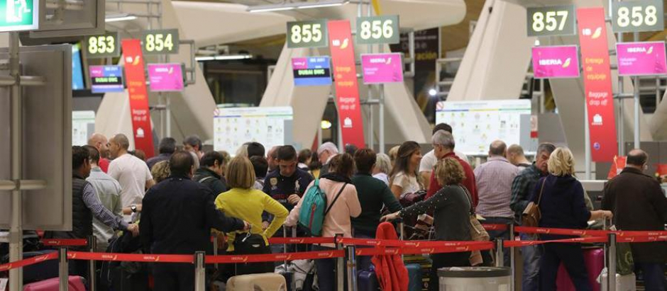 Viajeros esperan para facturar sus maletas en un mostrador del aeropuerto Adolfo Suárez Madrid-Barajas