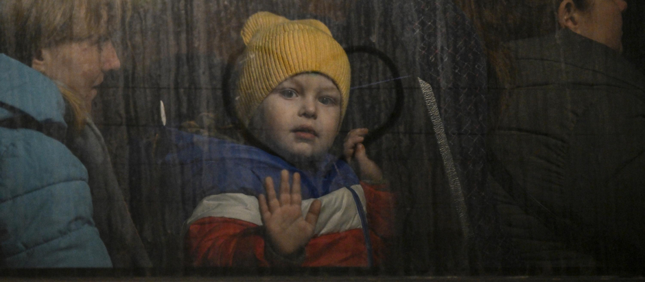 Un niño ucraniano saluda desde la ventana de un autobús de evacuación, el 14 de marzo