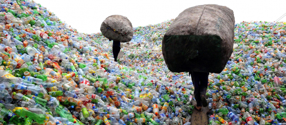 Trabajadores cargan con botellas en una planta de reciclaje de plásticos en China
